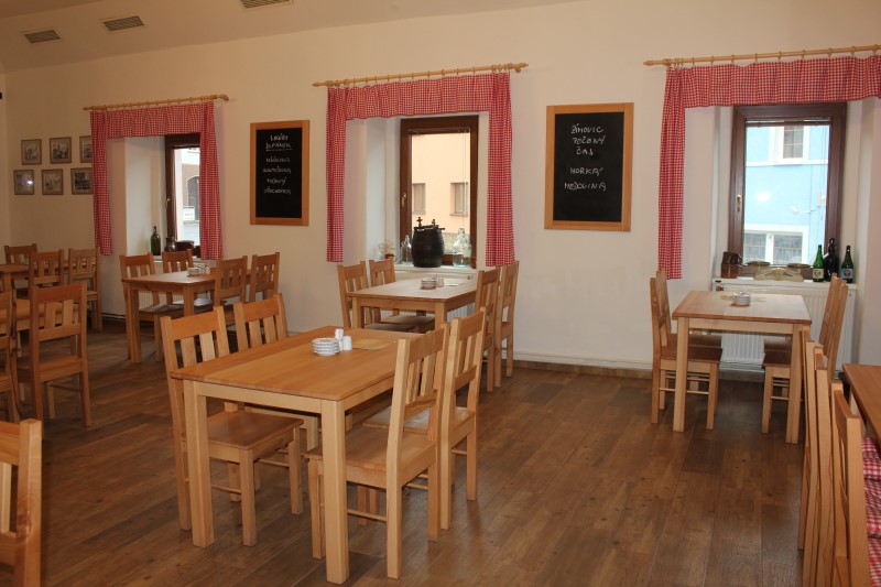 Dřevěné stoly a židle v salónku restaurace